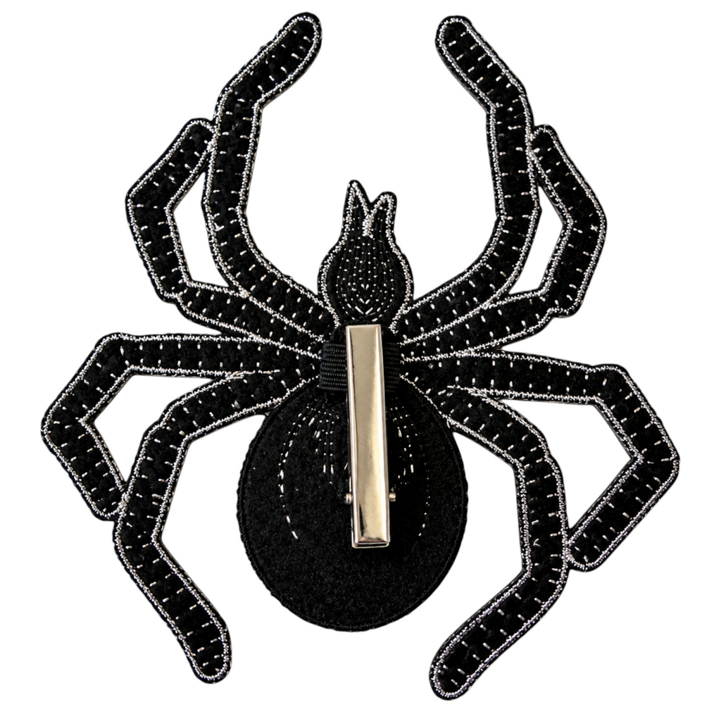The Matthew John Collective 6-inch black felt spider with silver embroidered stitching and a metal clip on the back.