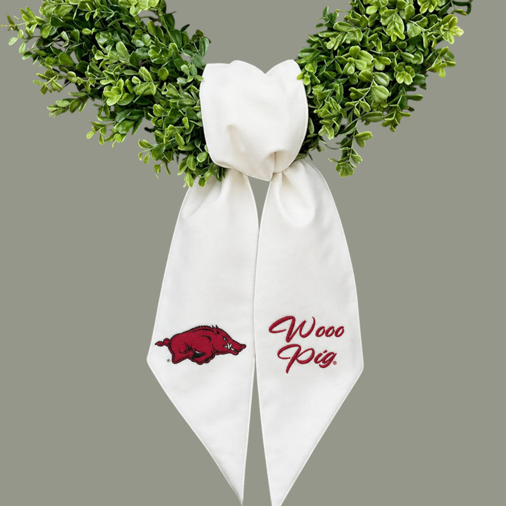 The Matthew John Collective white Arkansas wreath sash with red embroidered Razorback logo and Wooo Pig text