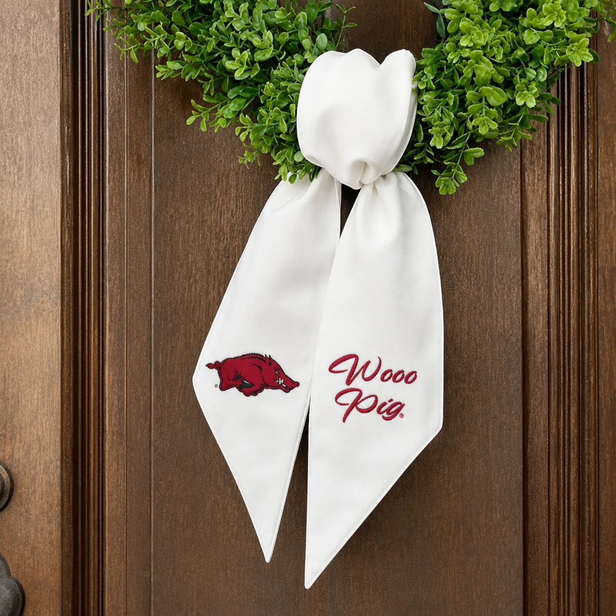 The Matthew John Collective white Arkansas wreath sash with red embroidered Razorback logo and Wooo Pig text.