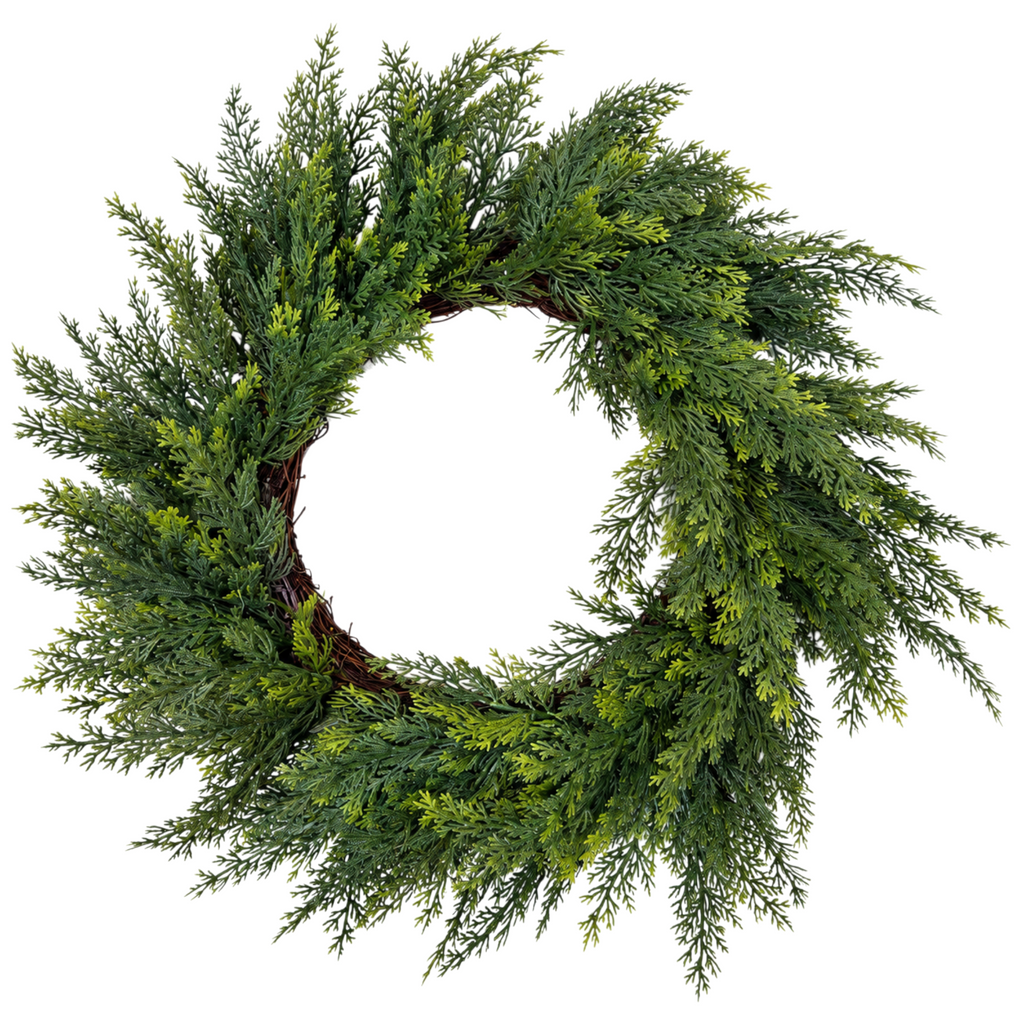 The Matthew John Collective 18-inch artificial cedar wreath with feathery green foliage on a rustic grapevine base.