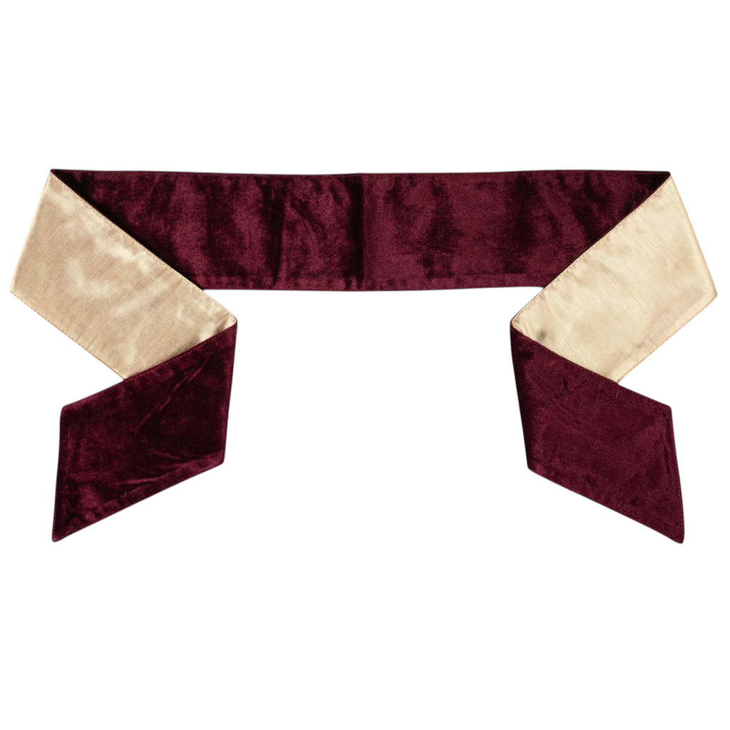 The Matthew John Collective burgundy velvet wreath sash with a metallic gold satin reverse and pointed ends.