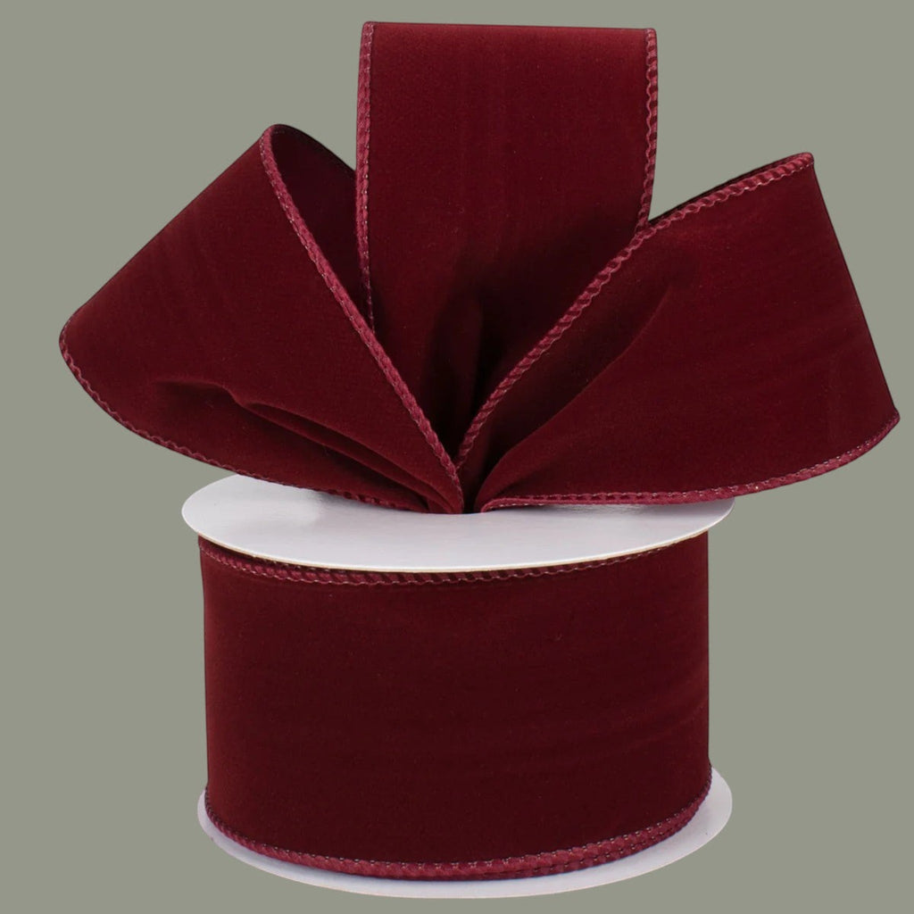 The Matthew John Collective burgundy velvet ribbon with wired edges on a spool for holiday and craft decorating.