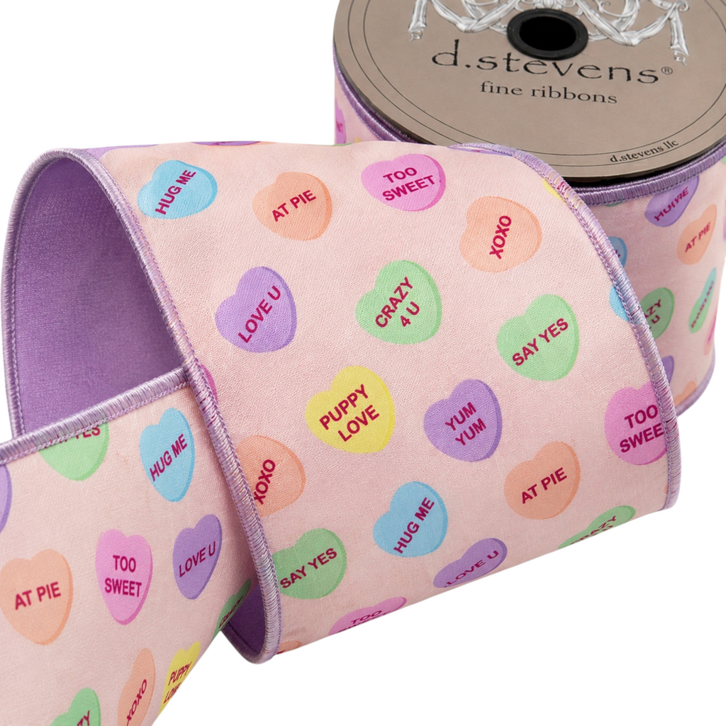 The Matthew John Collective D Stevens satin ribbon with pastel conversation hearts on a blush pink background