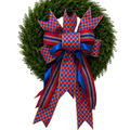 The Matthew John Collective handmade red, blue, and gold diamond patterned designer bow on a green boxwood wreath.