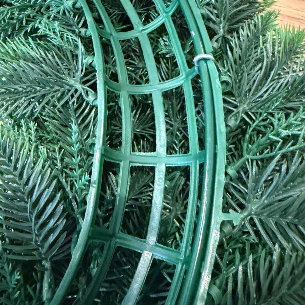 The Matthew John Collective 22 inch mixed evergreen wreath showing the sturdy green plastic grid backing frame.