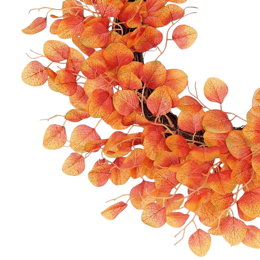 The Matthew John Collective 24-inch fall wreath featuring orange and yellow silk-screen silver dollar eucalyptus leaves.