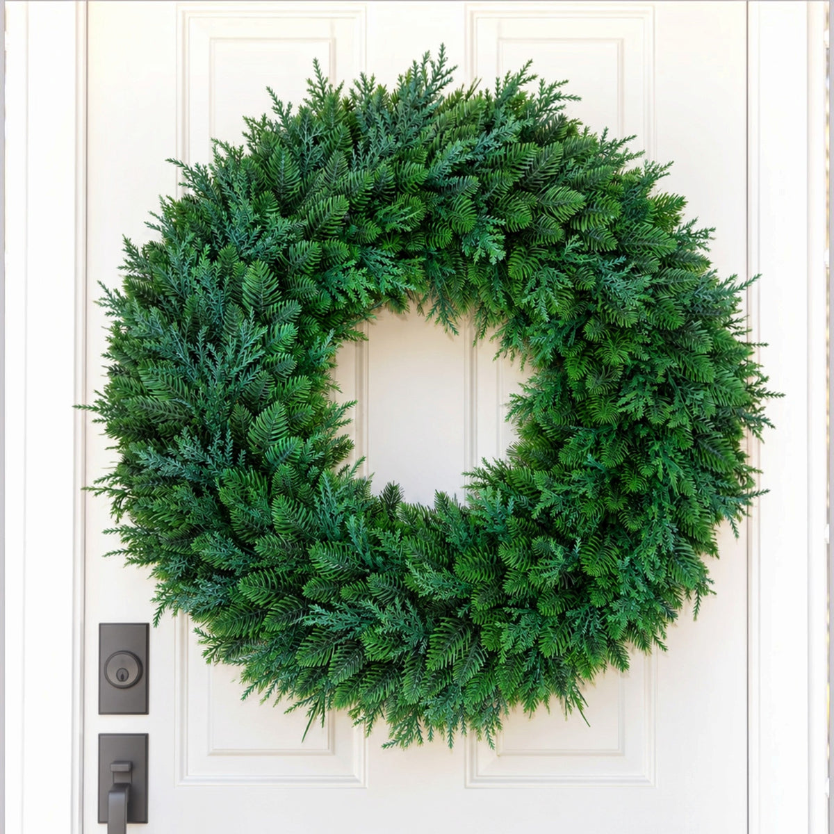 The Matthew John Collective 22-inch round mixed evergreen wreath with realistic faux cedar and pine on a white door.
