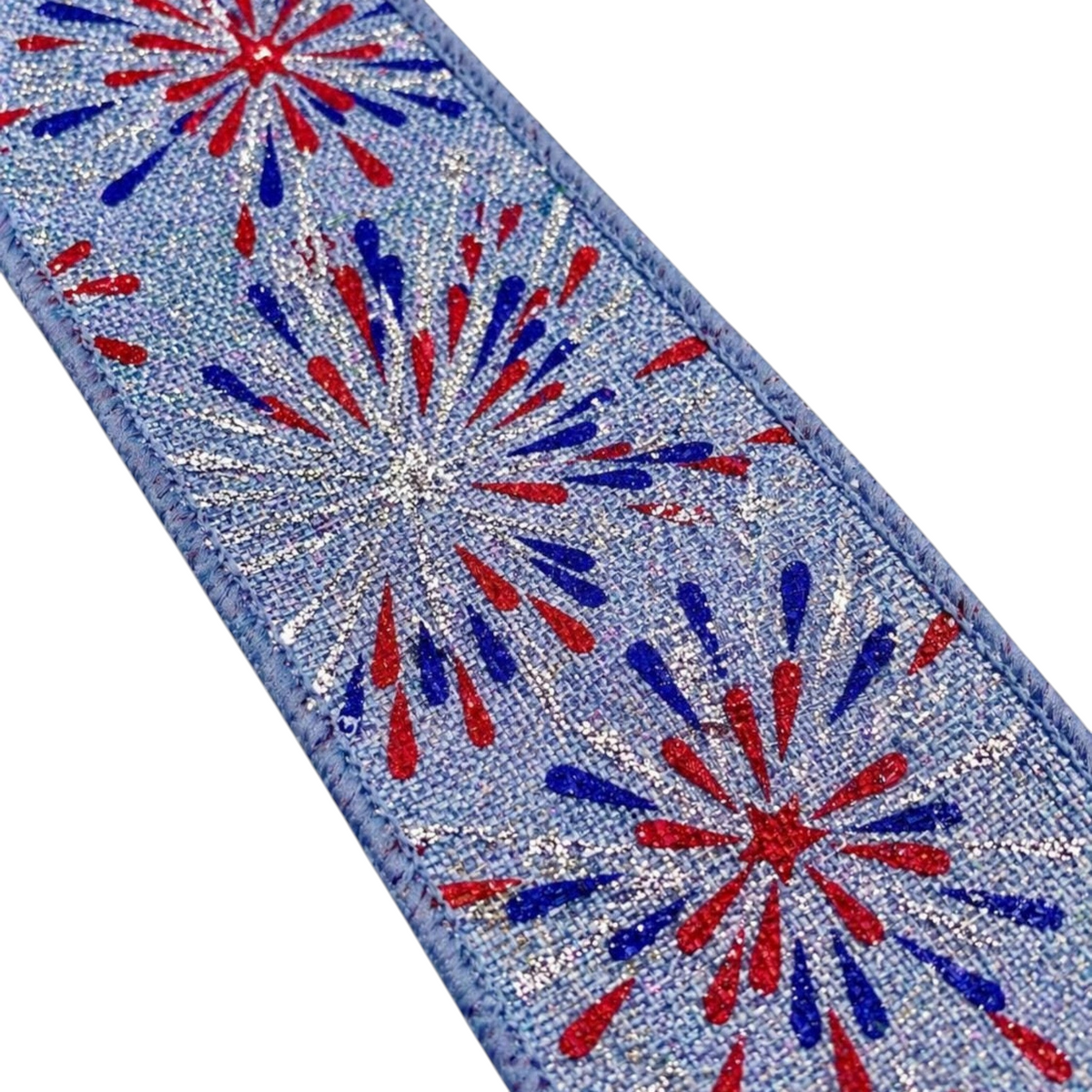 The Matthew John Collective 1.5 inch wired ribbon with red, blue, and silver firework print on a denim-look blue base.