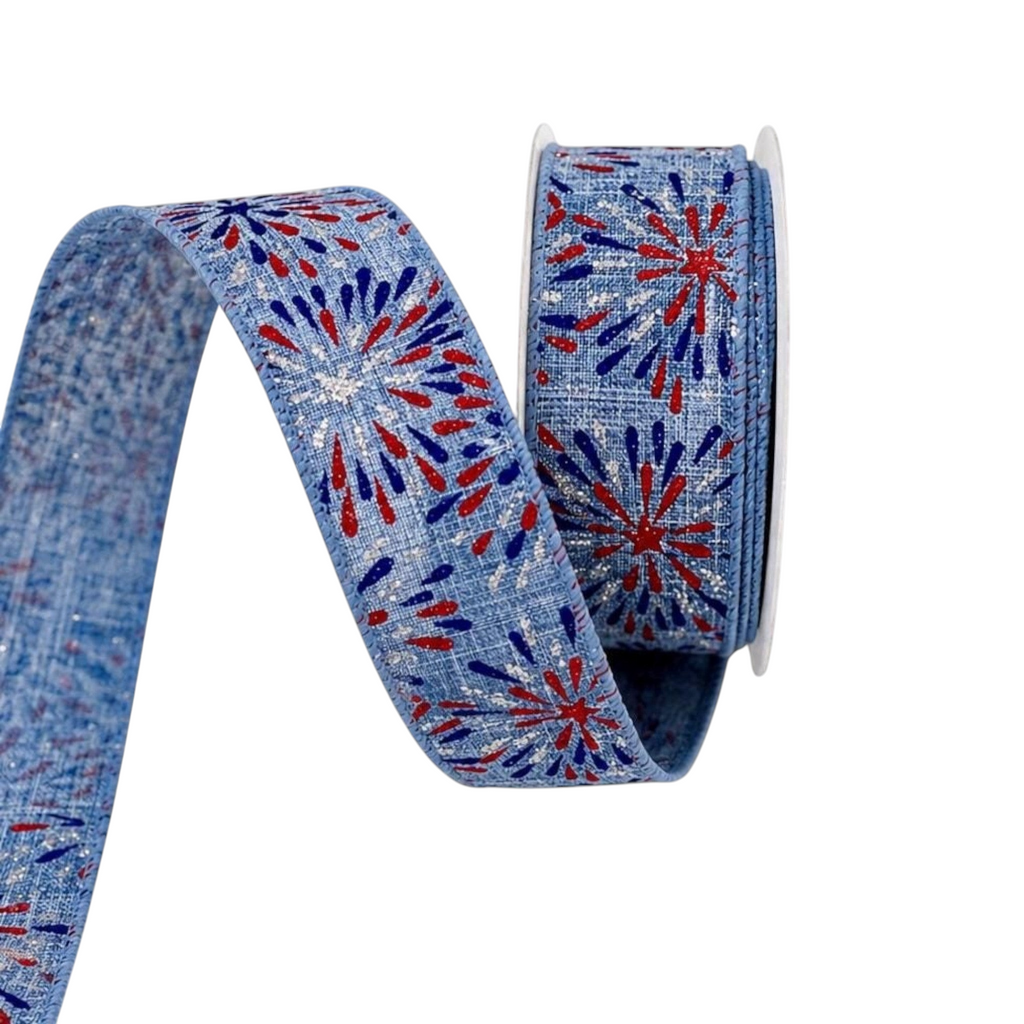 The Matthew John Collective 1.5 inch wired ribbon with red, blue, and silver firework print on a denim-look blue base.