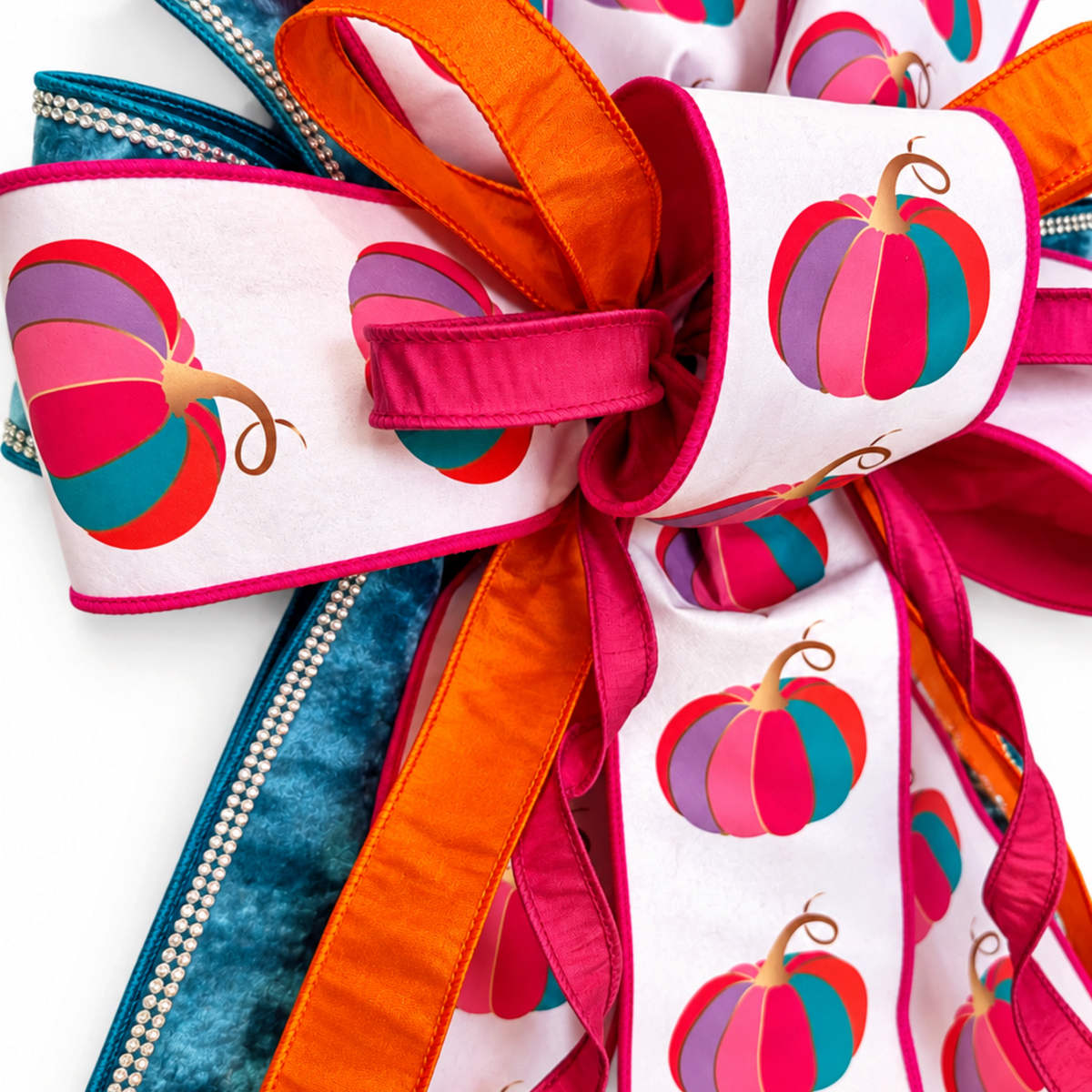 The Matthew John Collective oversized fall wreath bow with fuchsia pumpkin print, blue velvet, and rhinestone trim.
