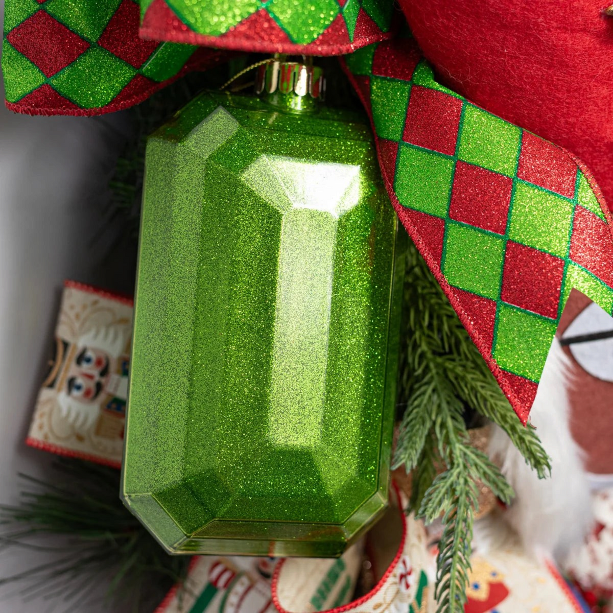The Matthew John Collective emerald green rectangular glitter gem ornament with faceted surfaces and gold hanging loop.