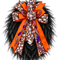 The Matthew John Collective oversized Halloween ghost wreath bow with orange, purple, and plaid ribbon tails.