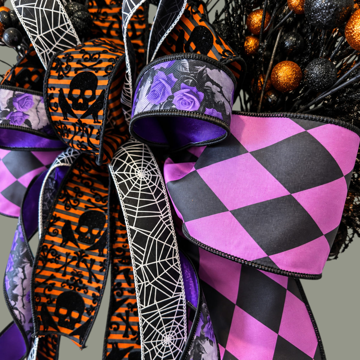 The Matthew John Collective Midnight Masquerade Halloween wreath featuring a designer bow with harlequin and skull print