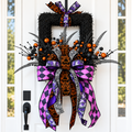 The Matthew John Collective Midnight Masquerade Halloween wreath with purple, orange, and black designer ribbon tails.