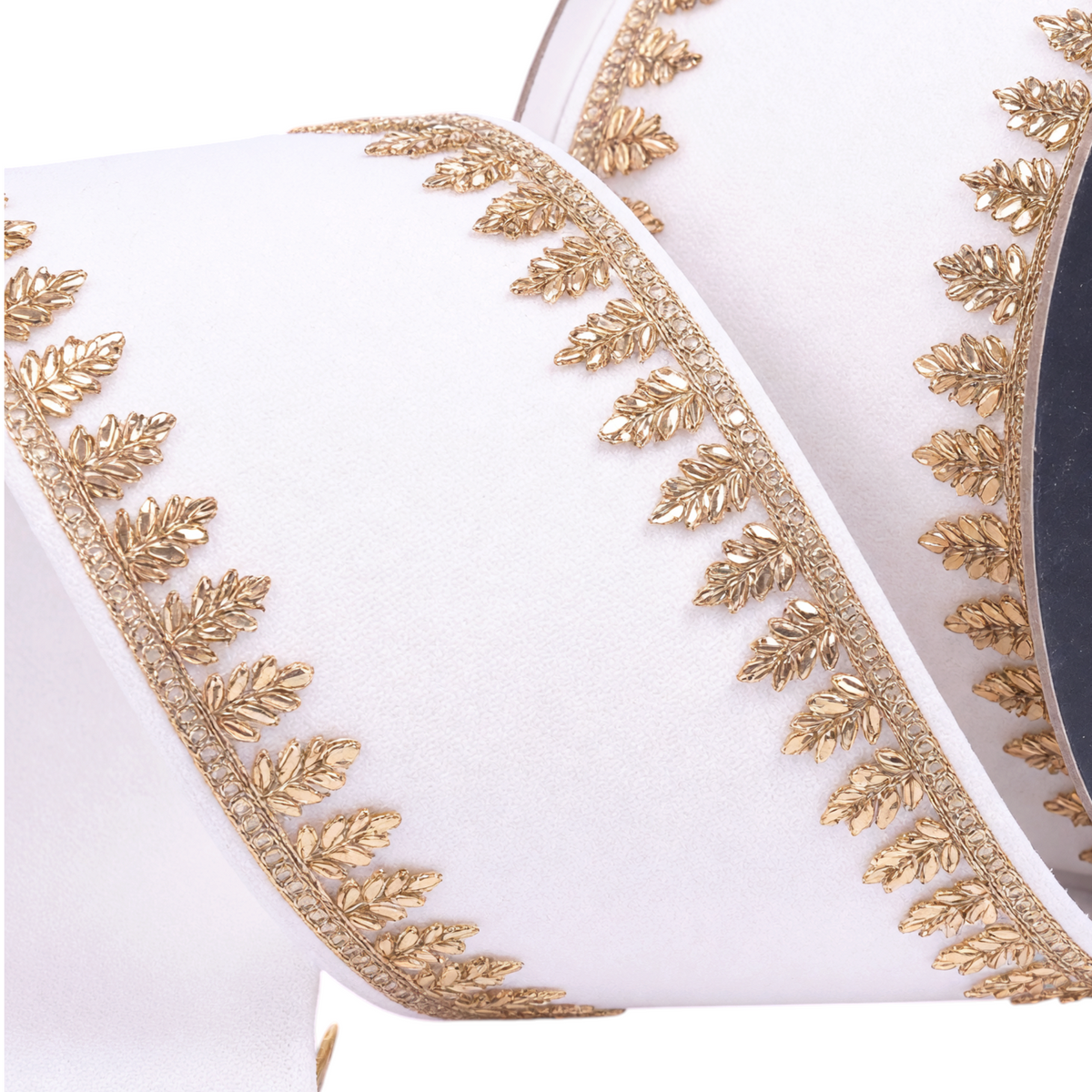 The Matthew John Collective Farrisilk Pinyon Jewel ivory holiday ribbon with metallic gold leaf-patterned trim edges.