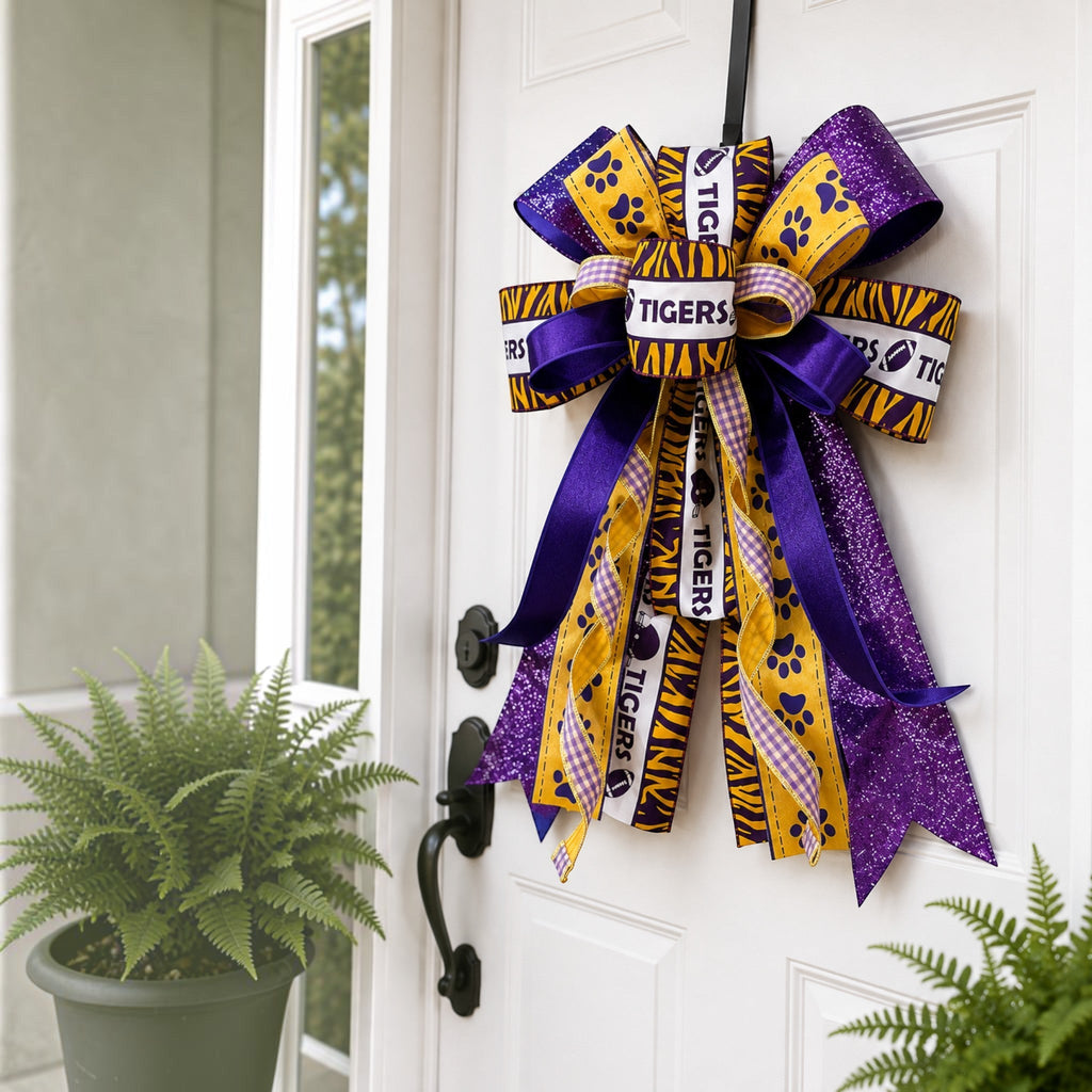 The Matthew John Collective LSU Tiger Paws Gameday Handmade Bow featuring purple, gold, and white wired ribbons.