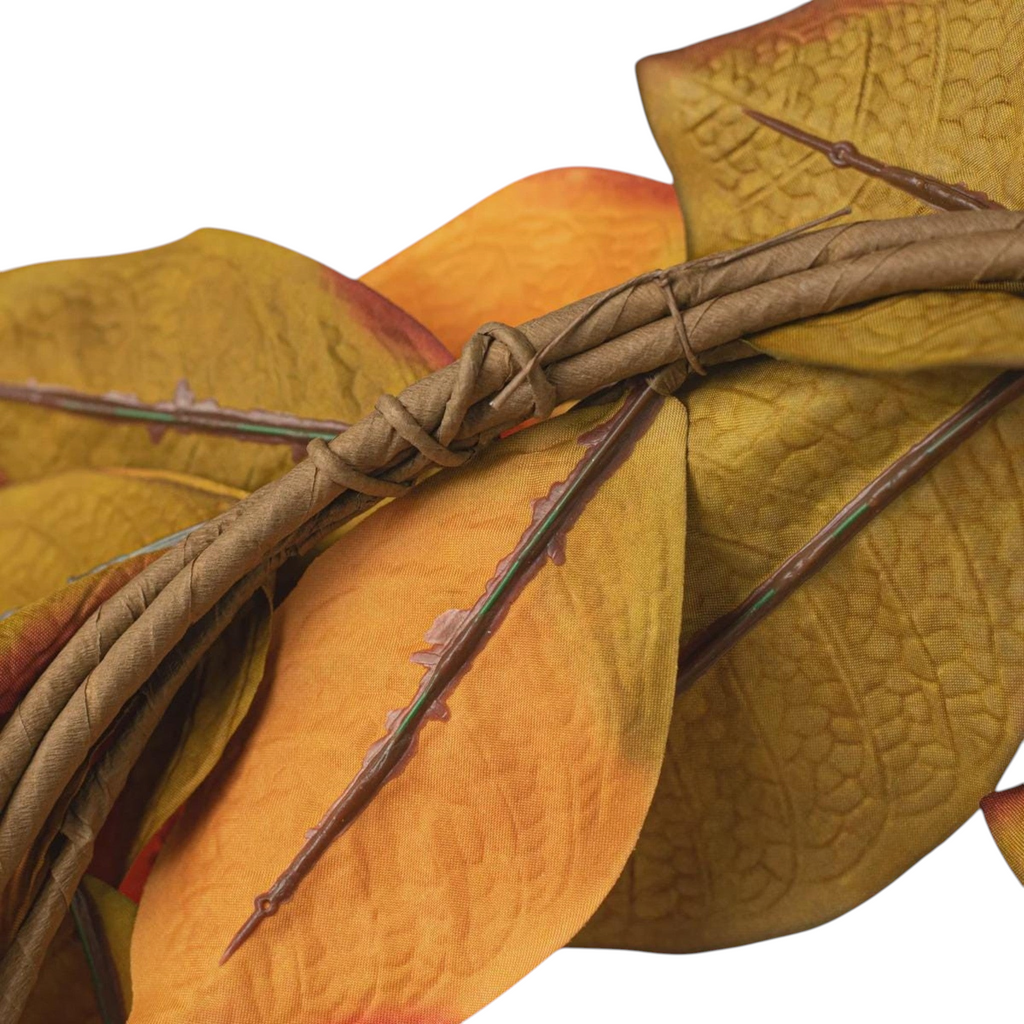 The Matthew John Collective 22-inch magnolia leaf wreath featuring variegated olive, orange, and burgundy fall leaves.