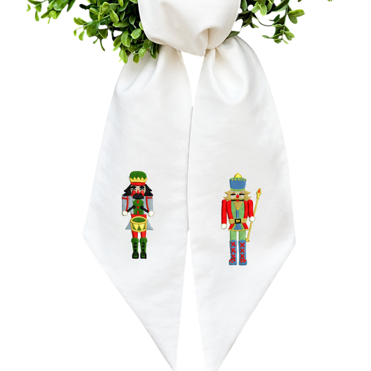 The Matthew John Collective white cotton canvas wreath sash with embroidered nutcracker soldiers for holiday decor.