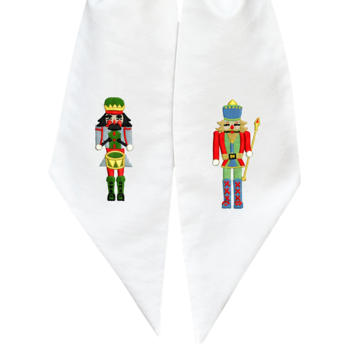 The Matthew John Collective white cotton canvas wreath sash with embroidered nutcracker soldier and drummer designs.