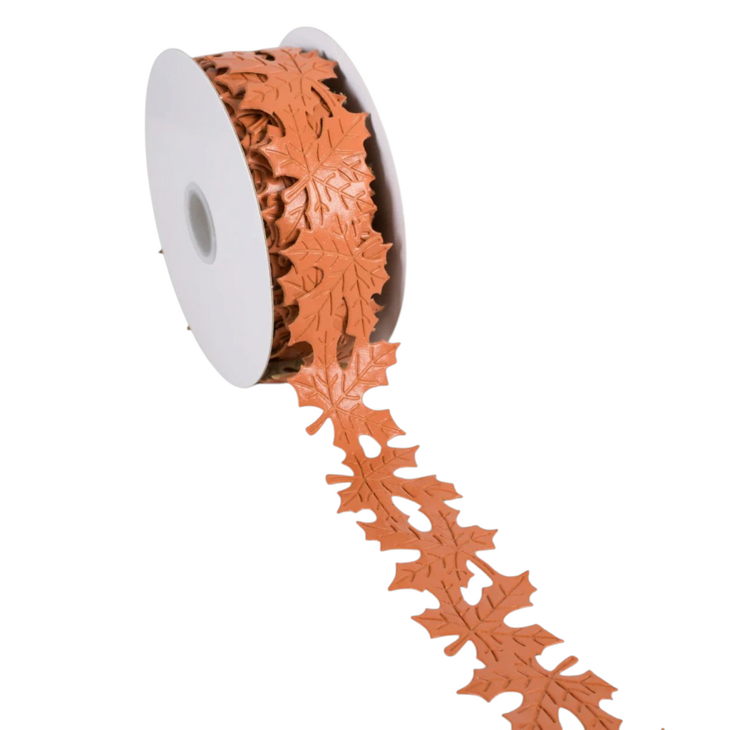 The Matthew John Collective terracotta orange faux leather ribbon with a die-cut maple leaf pattern for fall decor.
