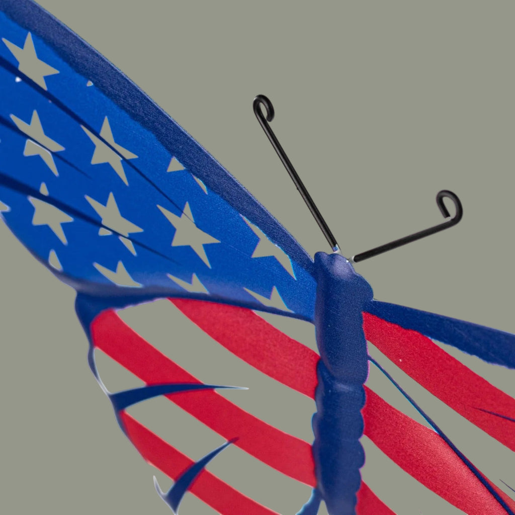 The Matthew John Collective patriotic metal swallowtail butterfly sign with red, white, and blue flag pattern.