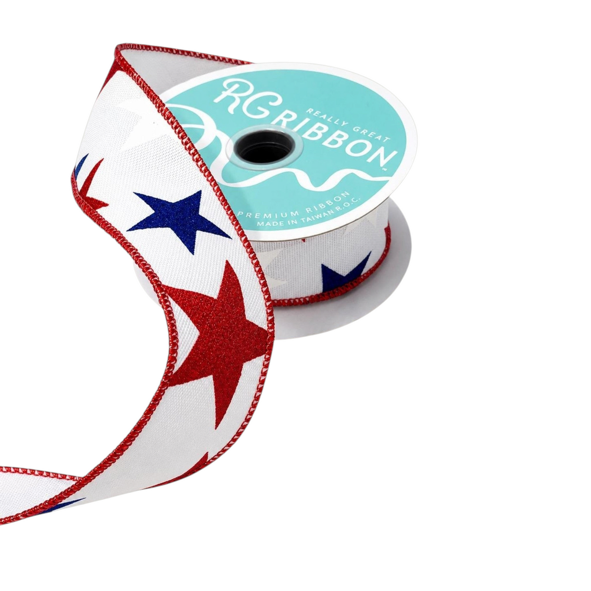 The Matthew John Collective white satin ribbon with red and blue glitter stars and red wire-edged trim on a spool.
