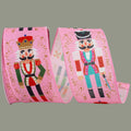 The Matthew John Collective pink wired edge ribbon featuring festive nutcracker figures and gold scrollwork patterns.