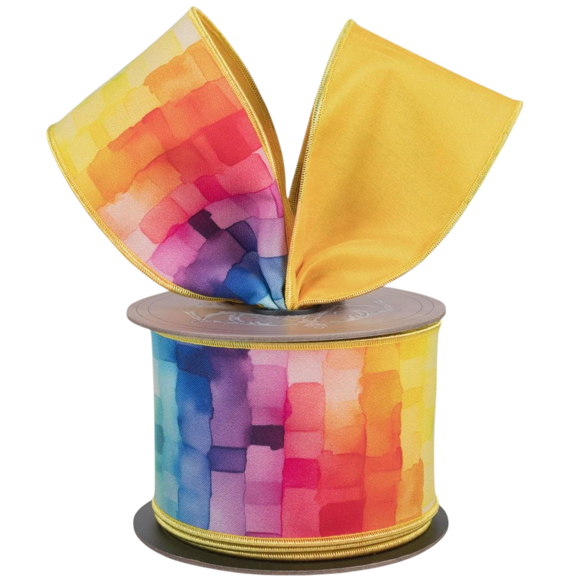 The Matthew John Collective 2.5-inch taffeta ribbon featuring a rainbow watercolor mosaic cube pattern on a spool.