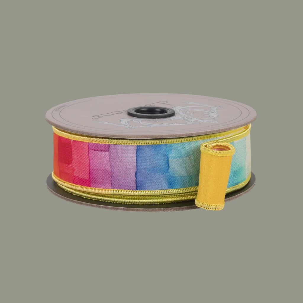 The Matthew John Collective 1-inch taffeta ribbon featuring a rainbow watercolor mosaic pattern on a spool.
