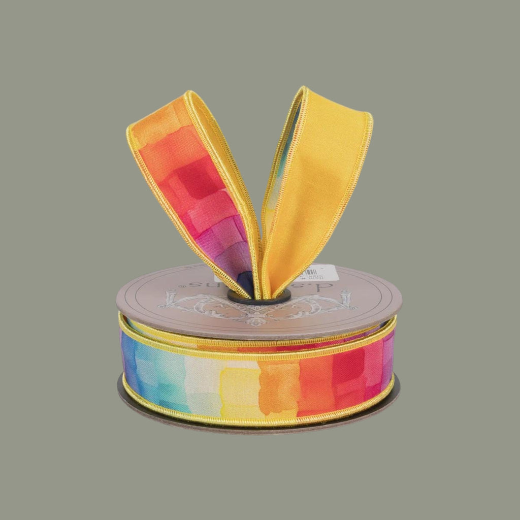 The Matthew John Collective D Stevens 1-inch taffeta ribbon with a rainbow watercolor mosaic pattern on a spool.