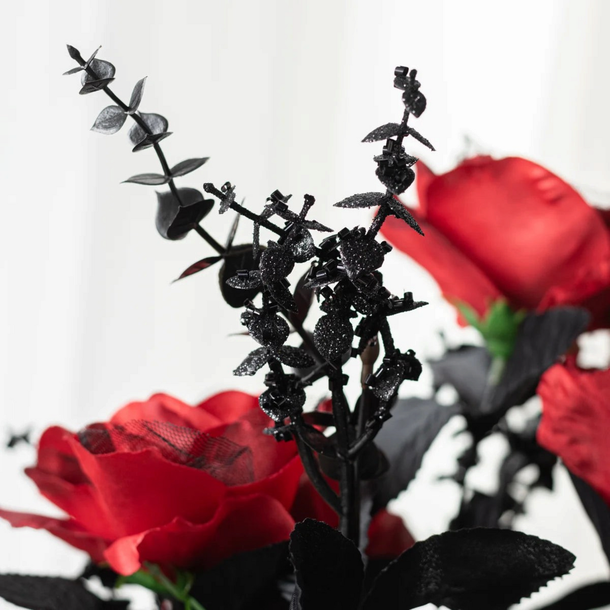 The Matthew John Collective red silk rose and black glittery eucalyptus bush for Gothic Halloween floral decor