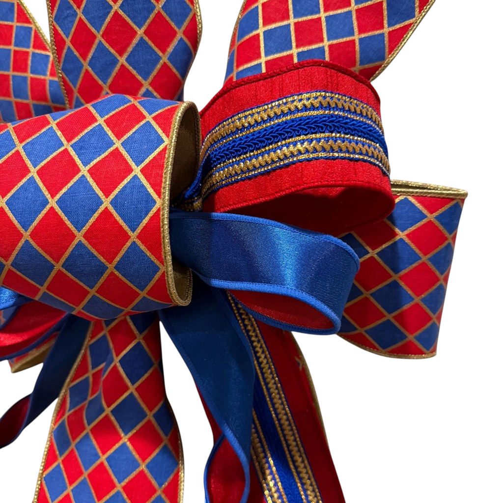 The Matthew John Collective handmade decorative bow featuring a red and blue diamond pattern with gold trim accents.