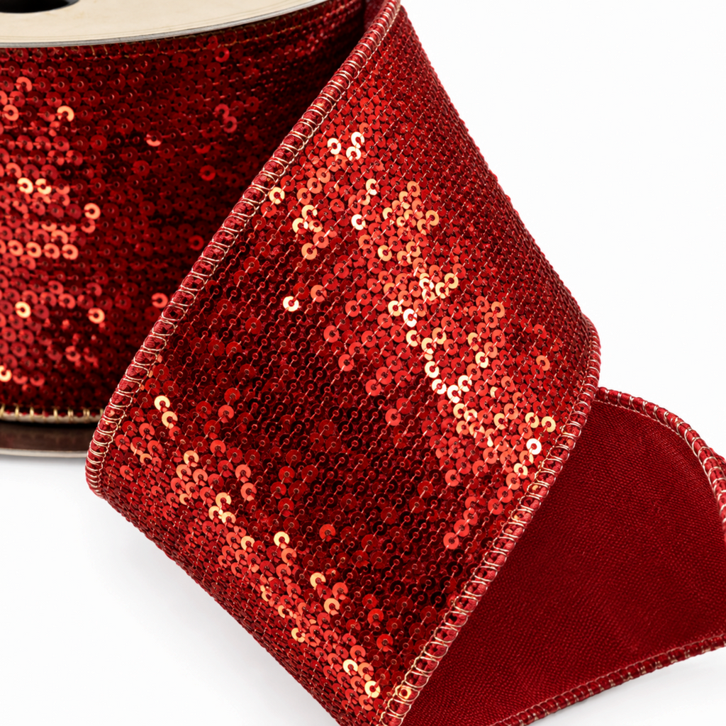 The Matthew John Collective red and gold sequin Christmas ribbon with a smooth red taffeta backing on a spool.