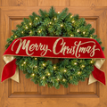 The Matthew John Collective red velvet Merry Christmas banner with gold glitter script draped over a lit wreath.