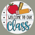 The Matthew John Collective 10.5-inch round classroom sign featuring a notebook paper design with school supplies.