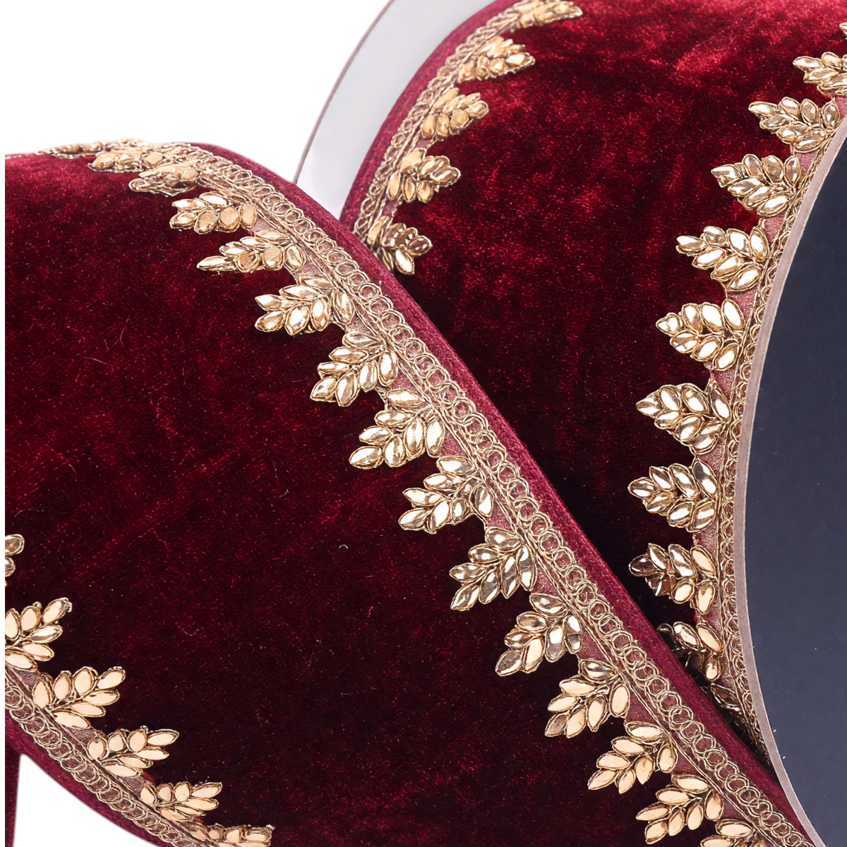 The Matthew John Collective Farrisilk ruby red velvet holiday ribbon with intricate gold metallic leaf-patterned trim.