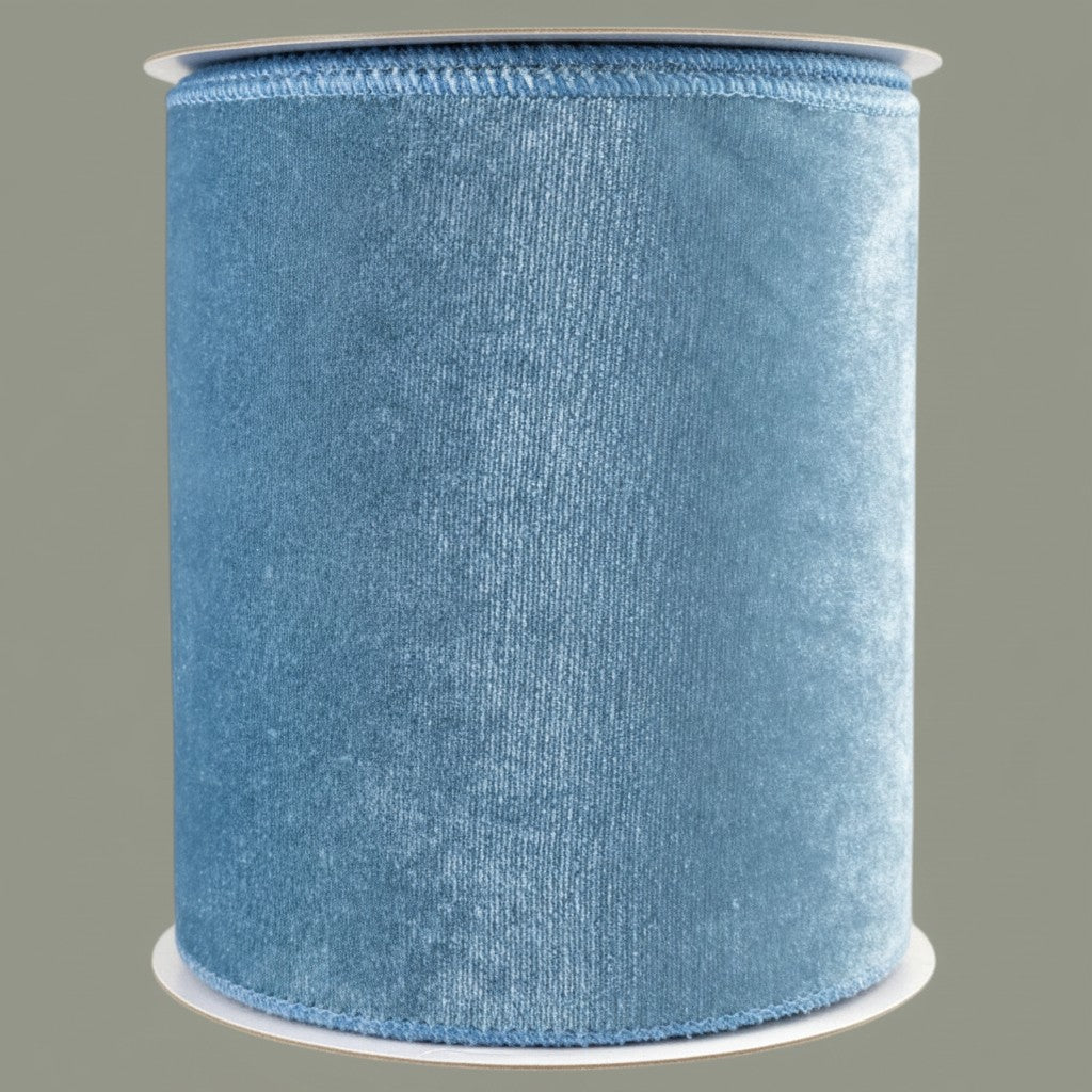 The Matthew John Collective smoke blue 6-inch wide velvet ribbon with satin backing and wired edges on a spool.