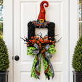The Matthew John Collective handcrafted Halloween wreath featuring a witch hat, orange florals, and a designer bow.