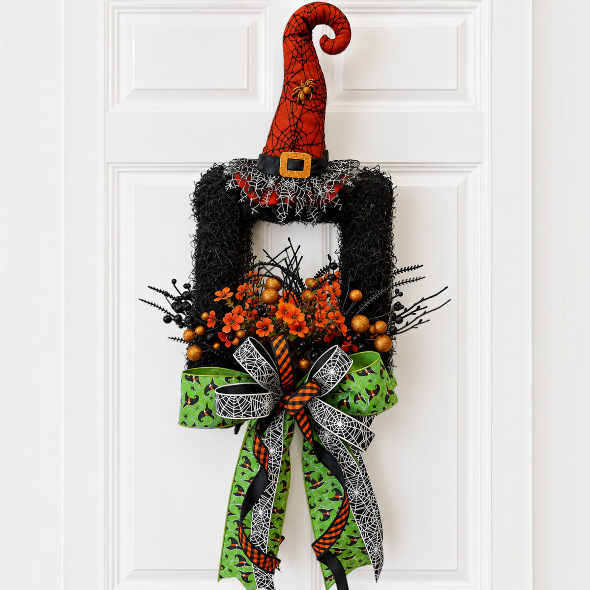 The Matthew John Collective handcrafted Halloween wreath featuring a witch hat, orange florals, and designer ribbons.