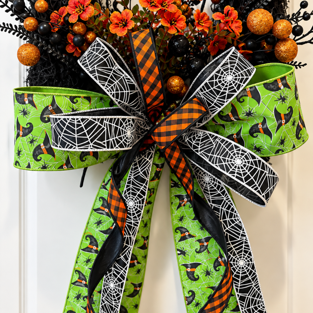 The Matthew John Collective Wicked Witch Halloween wreath featuring a large designer bow with green and spiderweb ribbon