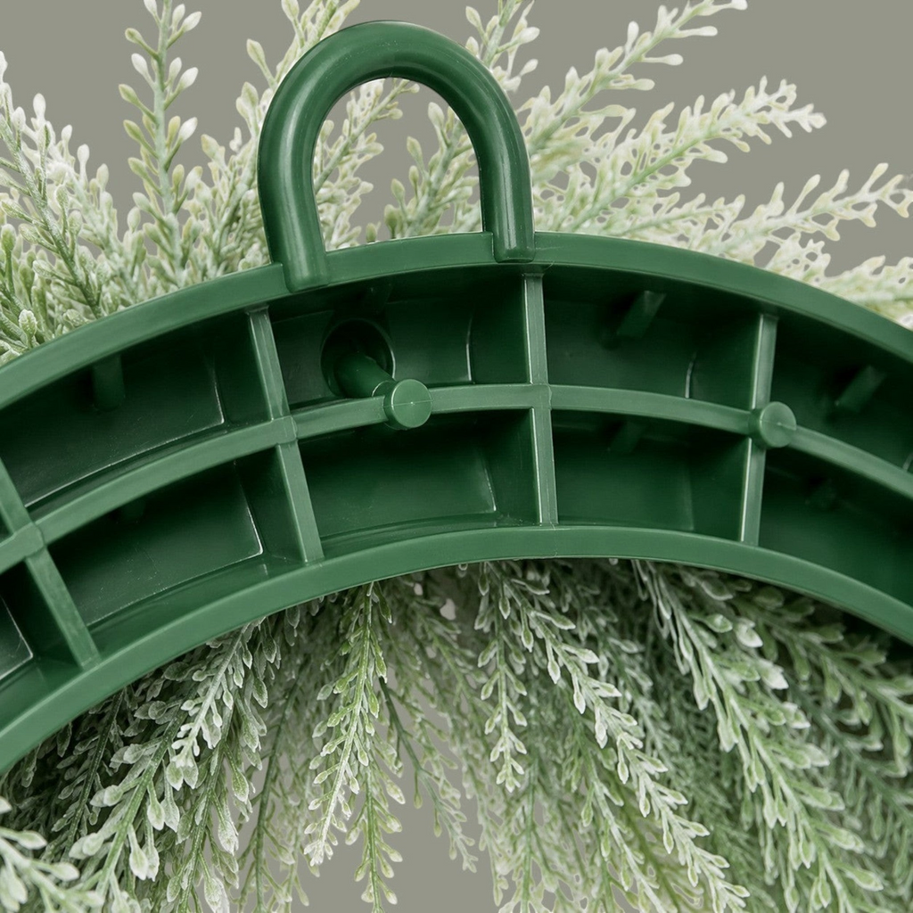 The Matthew John Collective frosted white bead grass wreath showing the sturdy green molded plastic backing and hanger.